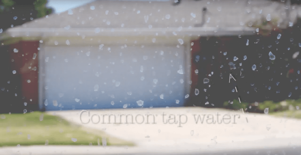 Common tap water with visible droplets on a surface, highlighting the contrast between municipal water and AquaOne's premium purified water.